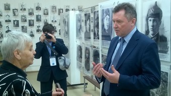 Руководитель проекта Семейные фотохроники Сергей Рыбальченко знакомится с экспозицией фотовыставки